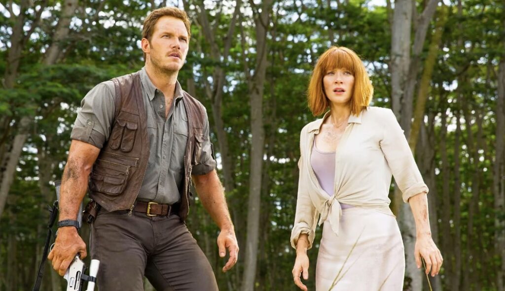 Chris Pratt and Bryce Dallas Howard in Jurassic World with worn clothing and roughed up looks in the forest.