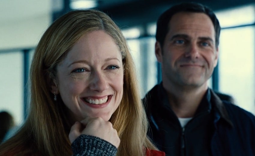 Judy Greer standing next to a man smiling with joy.