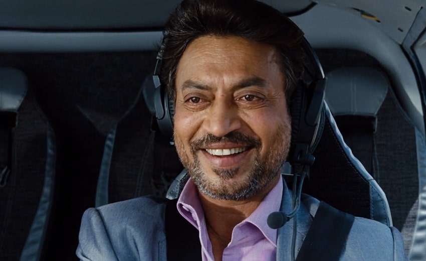 Irrfan Khan smiling happily inside a helicopter with a headset and blue suit.